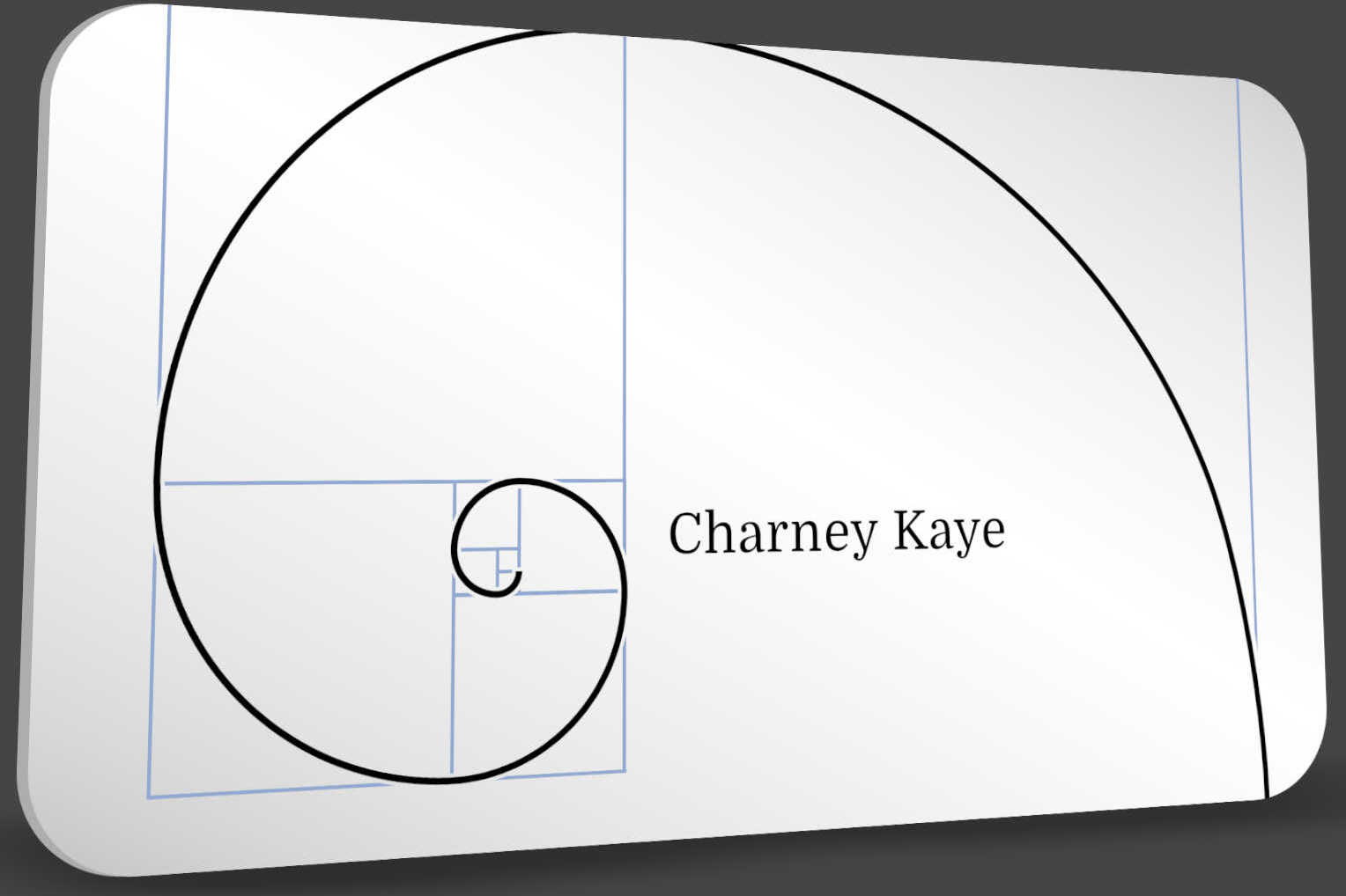 A white business card rendered in perspective — a golden spiral inked in black over its Fibonacci construction rectangles in pale blue, with "Charney Kaye" set in a classical serif at the spiral's eye